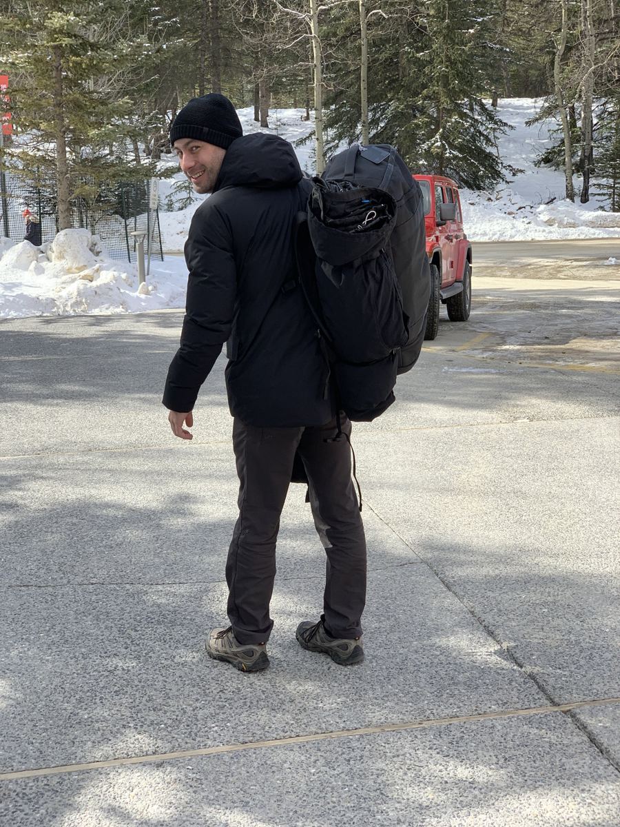 Manny with a large backpack in a snowy mountain town