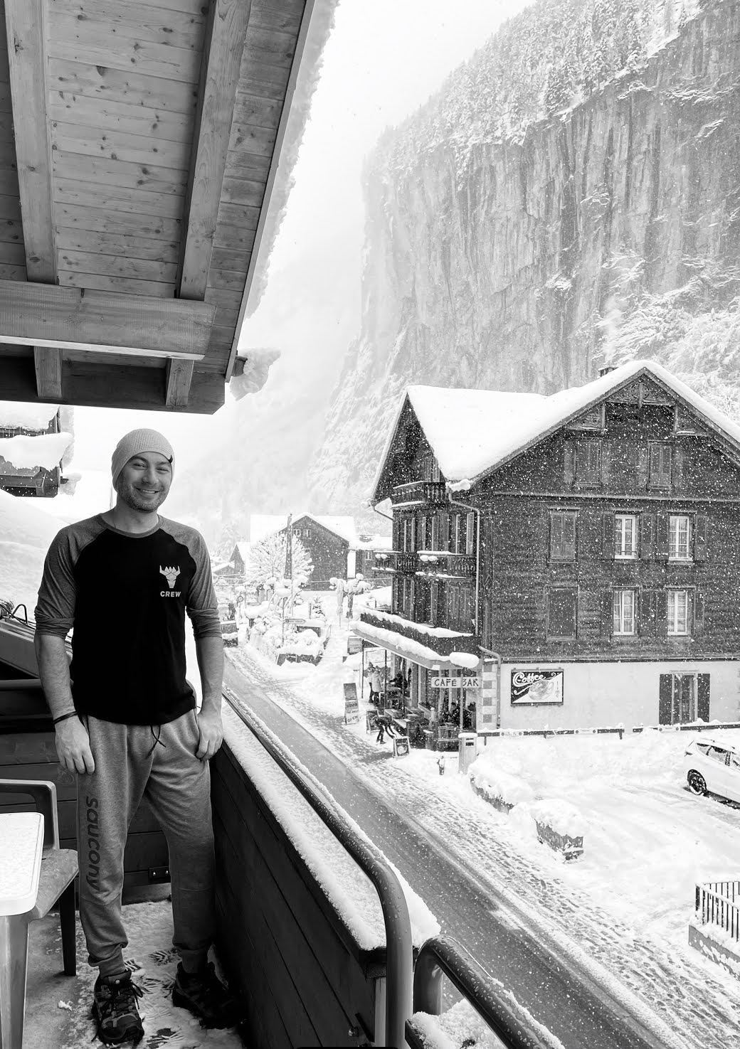 Black-and-white photo of Manny on a snowy chalet balcony