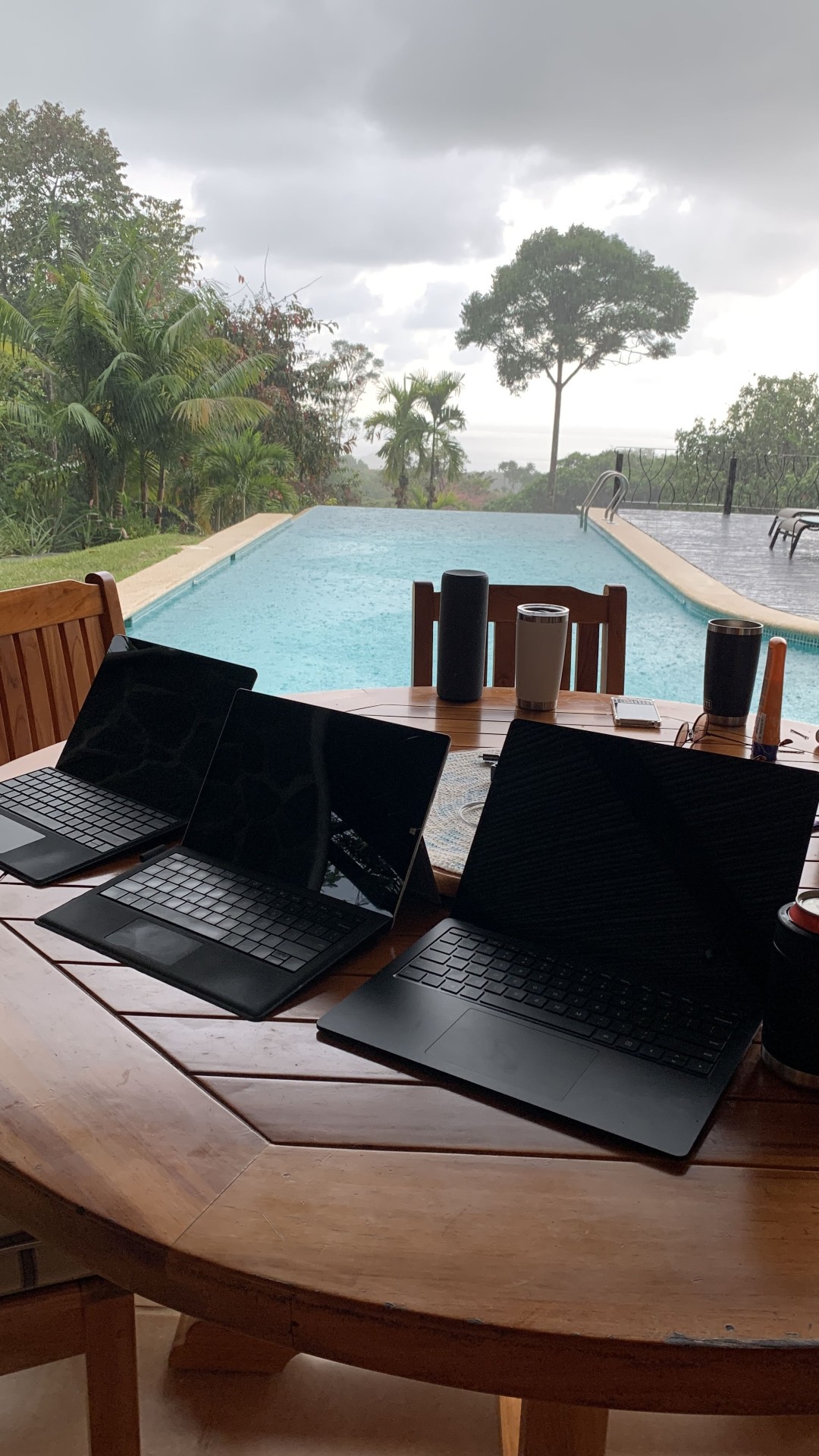 Poolside on a rainy day in Costa Rica working with others with multiple Surface devices